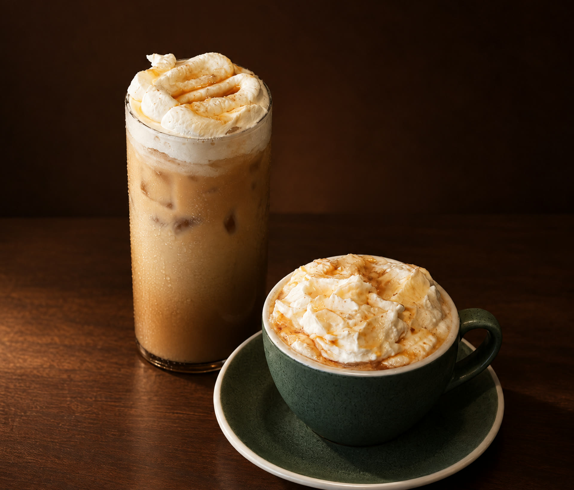 An iced and a hot Brown Butter Oat Latte, both topped with salted maple whipped cream